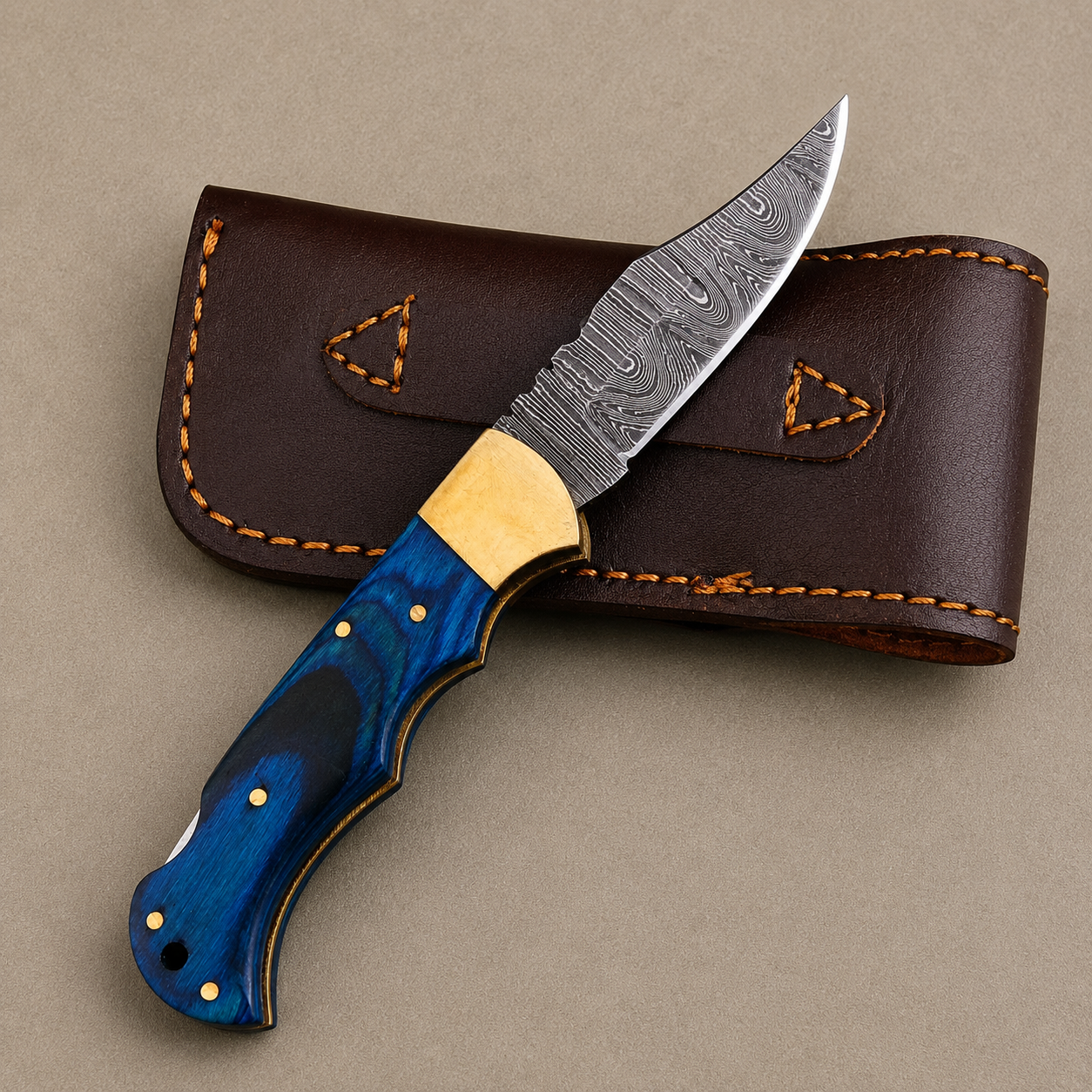Cobalt Crest Damascus Folding Knife – Hand Forged Steel with Blue Pakka Wood Handle, Brass Bolster & Leather Sheath