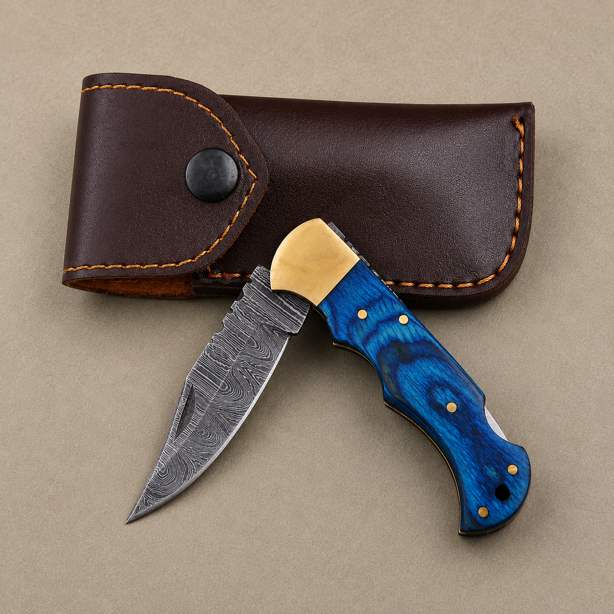 Cobalt Crest Damascus Folding Knife – Hand Forged Steel with Blue Pakka Wood Handle, Brass Bolster & Leather Sheath
