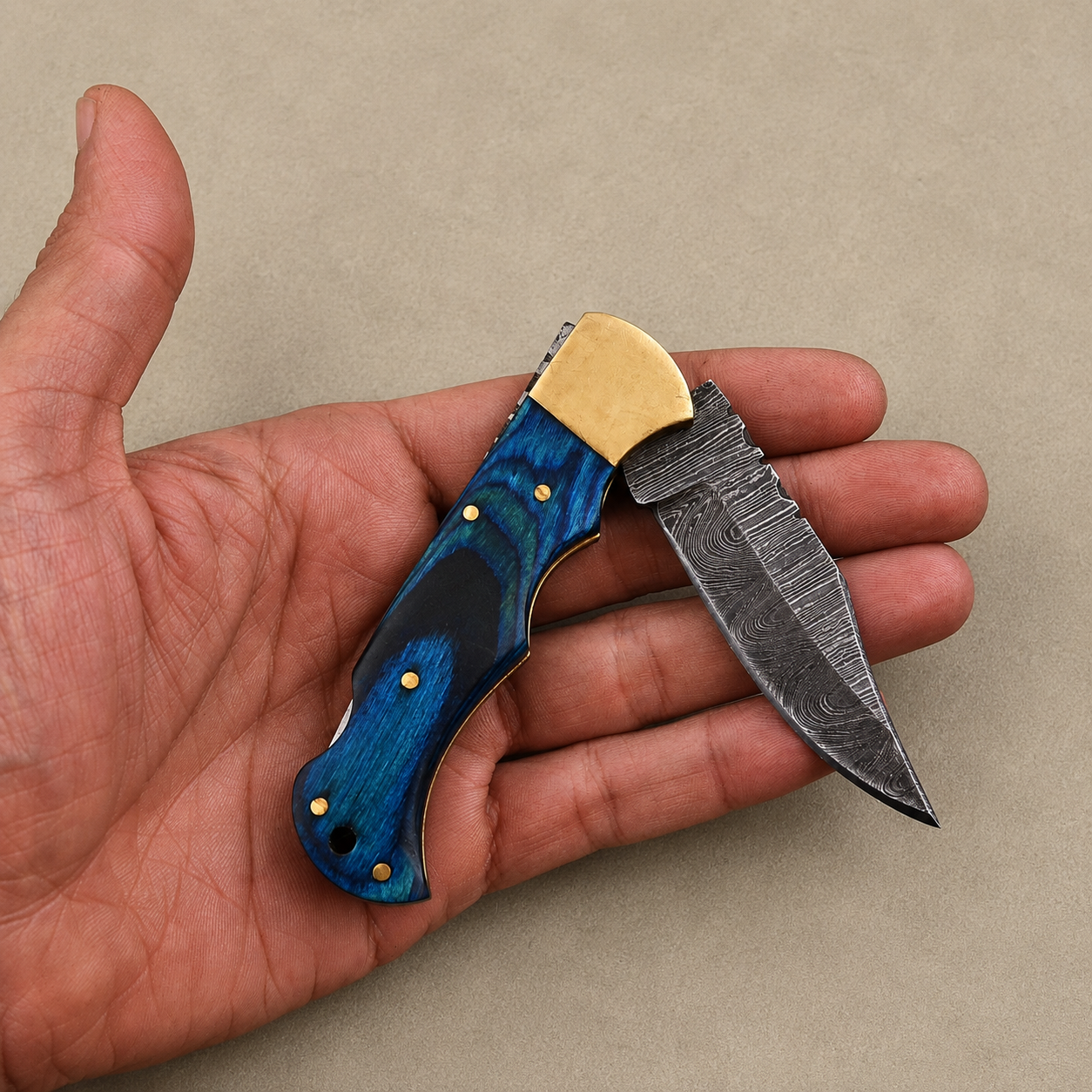 Cobalt Crest Damascus Folding Knife – Hand Forged Steel with Blue Pakka Wood Handle, Brass Bolster & Leather Sheath